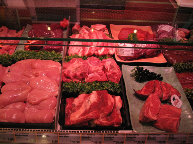 Выкладка мяса на витрине в магазине фото